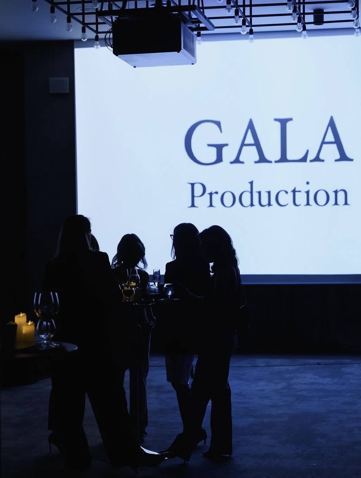 Guests networking beneath The Gala Production projection