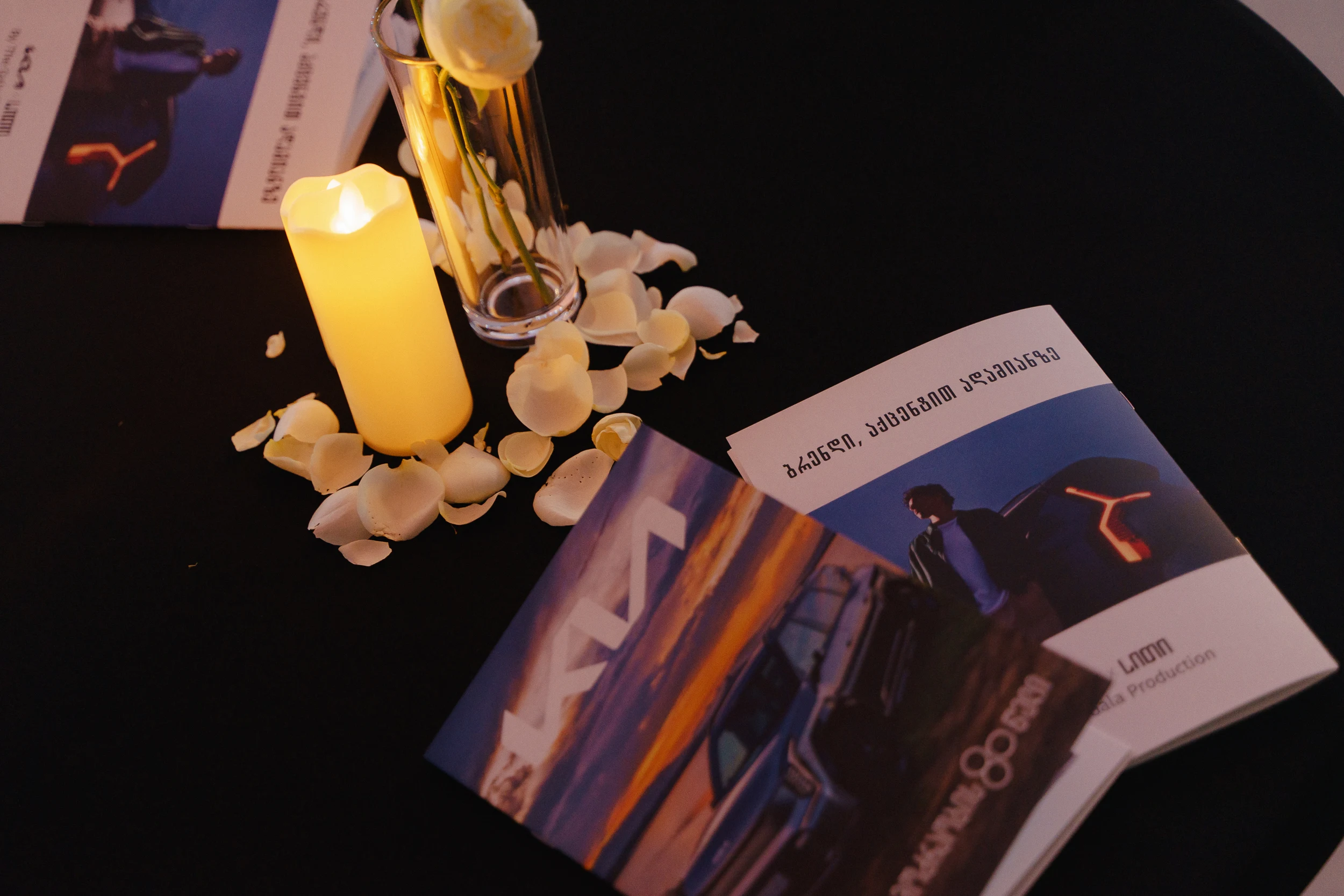 Event table styling with candles, flowers, and printed materials